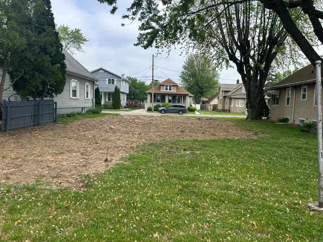 a front view of a house with a garden and trees