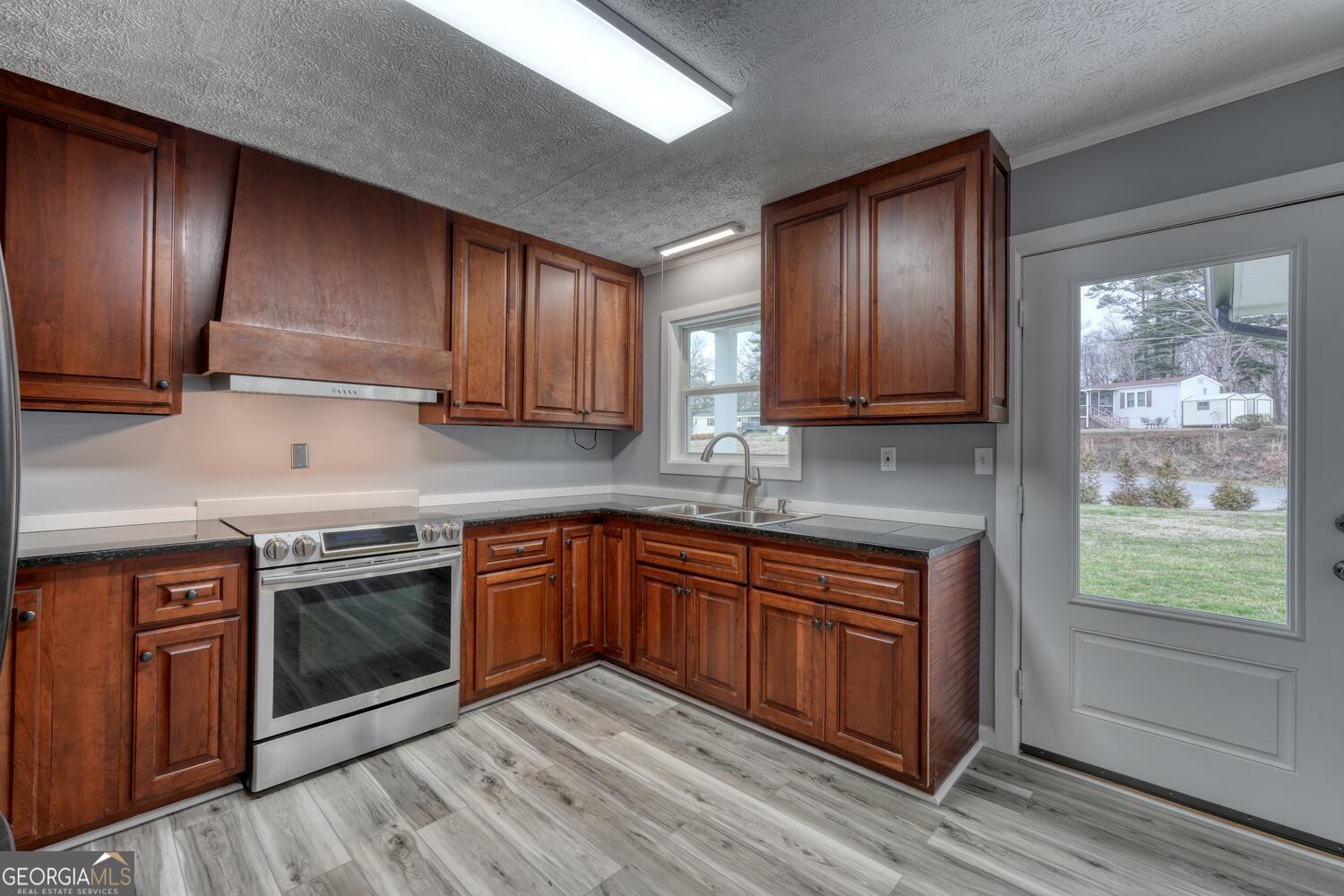 16 Antioch Church Road Blairsville, GA 30512 - Photo 14 of 36 a kitchen with wooden cabinets stainless steel appliances and a window