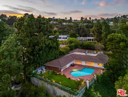 an aerial view of a house with a swimming pool outdoor seating and yard