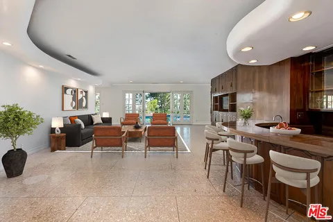 a living room with furniture a rug and white walls