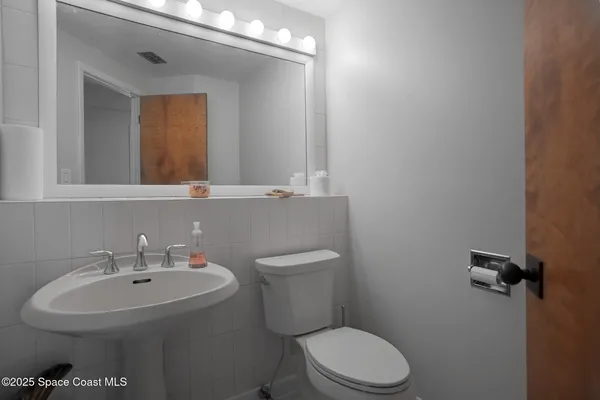 a bathroom with a sink a toilet and mirror