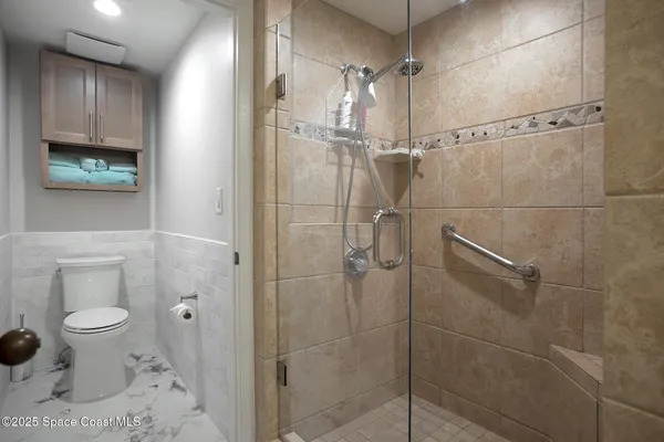 a bathroom with a toilet and a shower