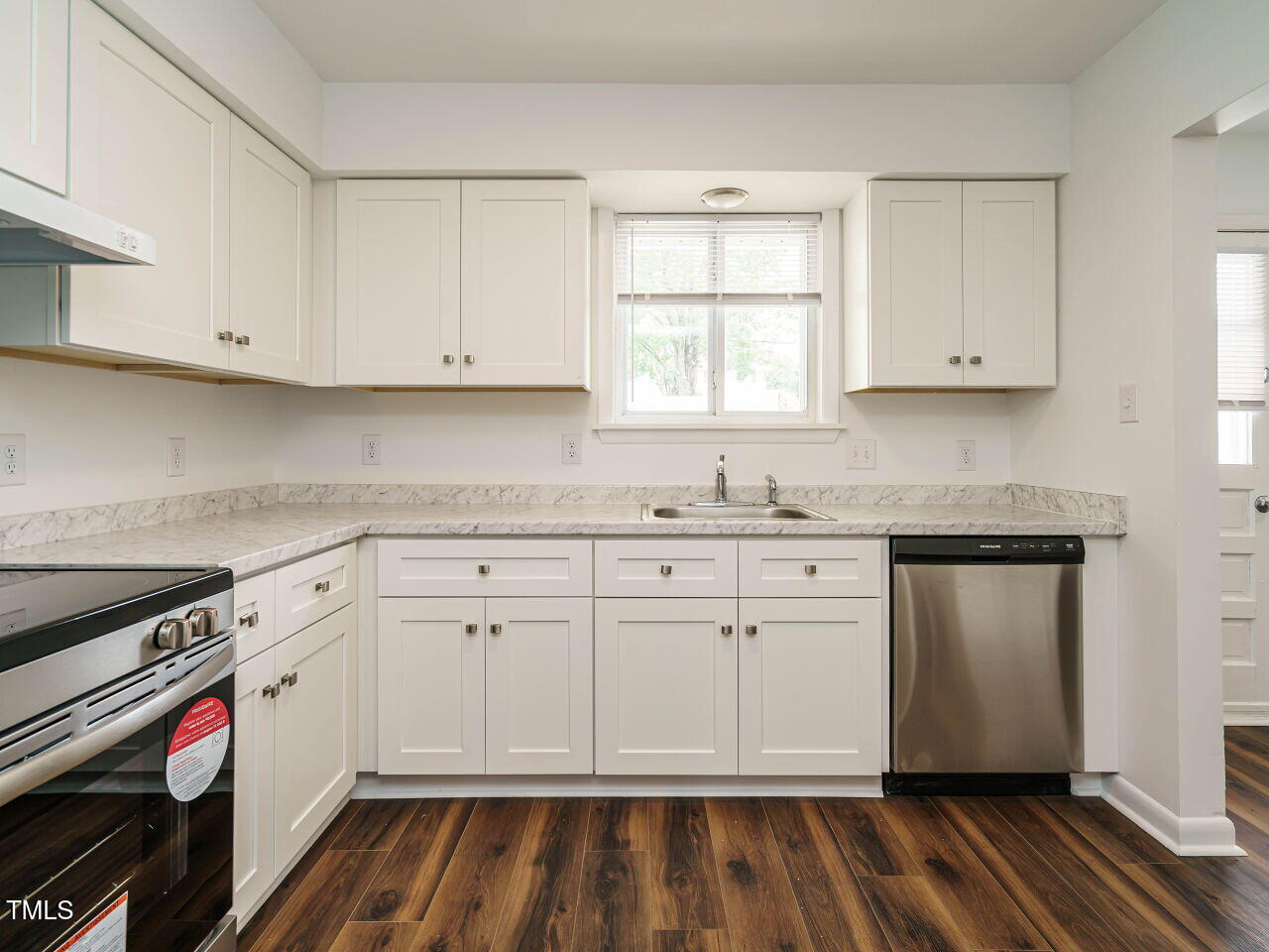 2316 Champion Court Raleigh, NC 27606 - Photo 14 of 27 a kitchen with granite countertop white cabinets and white appliances