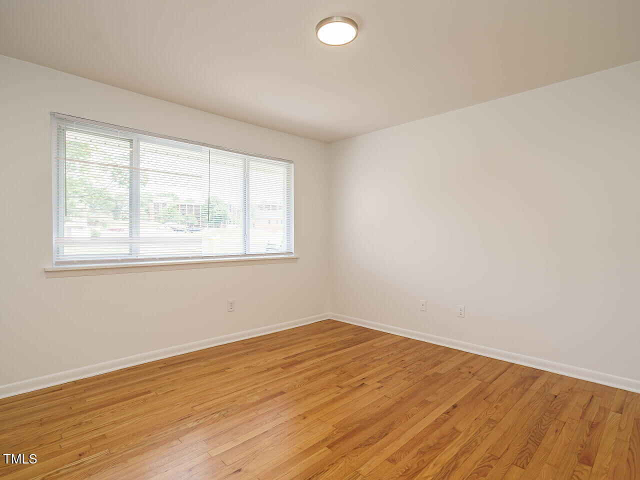 2316 Champion Court Raleigh, NC 27606 - Photo 18 of 27 an empty room with wooden floor and windows