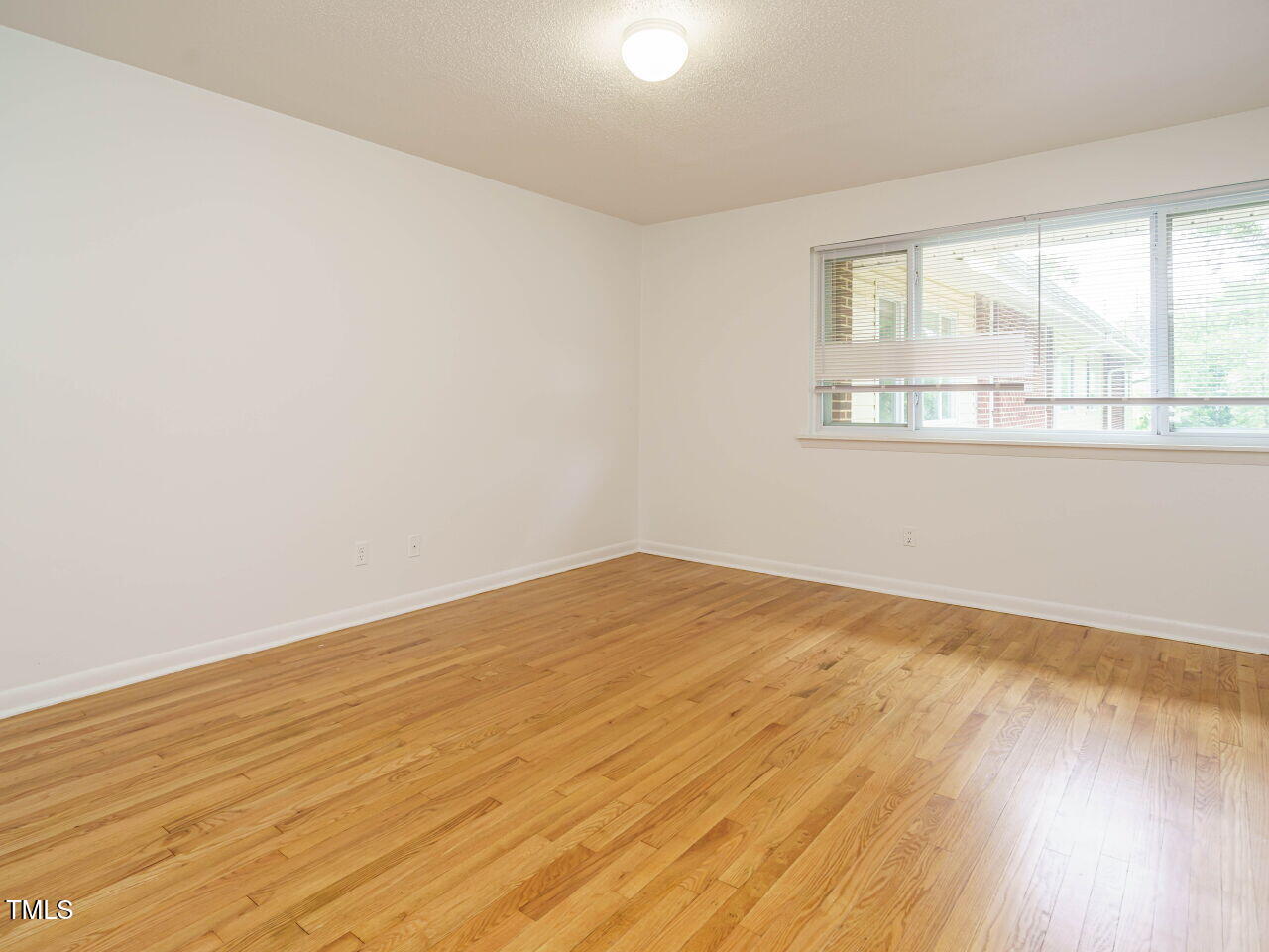 2316 Champion Court Raleigh, NC 27606 - Photo 21 of 27 wooden floor in an empty room with a window