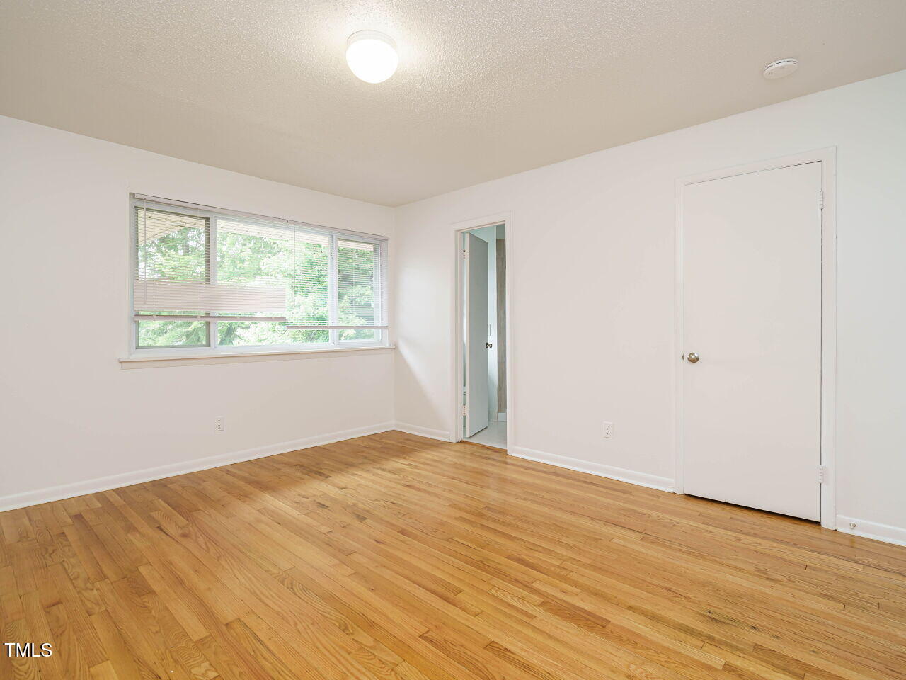 2316 Champion Court Raleigh, NC 27606 - Photo 22 of 27 a view of empty room with wooden floor and fan