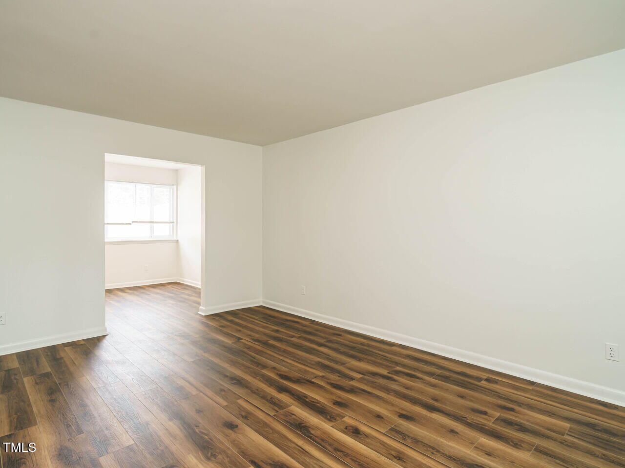 2316 Champion Court Raleigh, NC 27606 - Photo 7 of 27 an empty room with wooden floor and windows