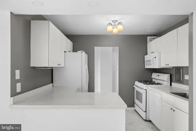 a kitchen with cabinets and white appliances