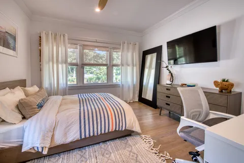 a bedroom with bed tv and window