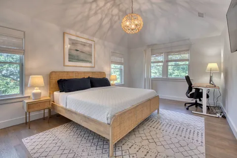 a bedroom with a bed and a table in it with window