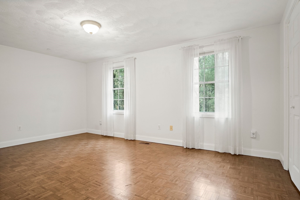 81 Salem Road, Unit 21 Billerica, MA 01821 - Photo 14 of 21 an empty room with wooden floor and windows