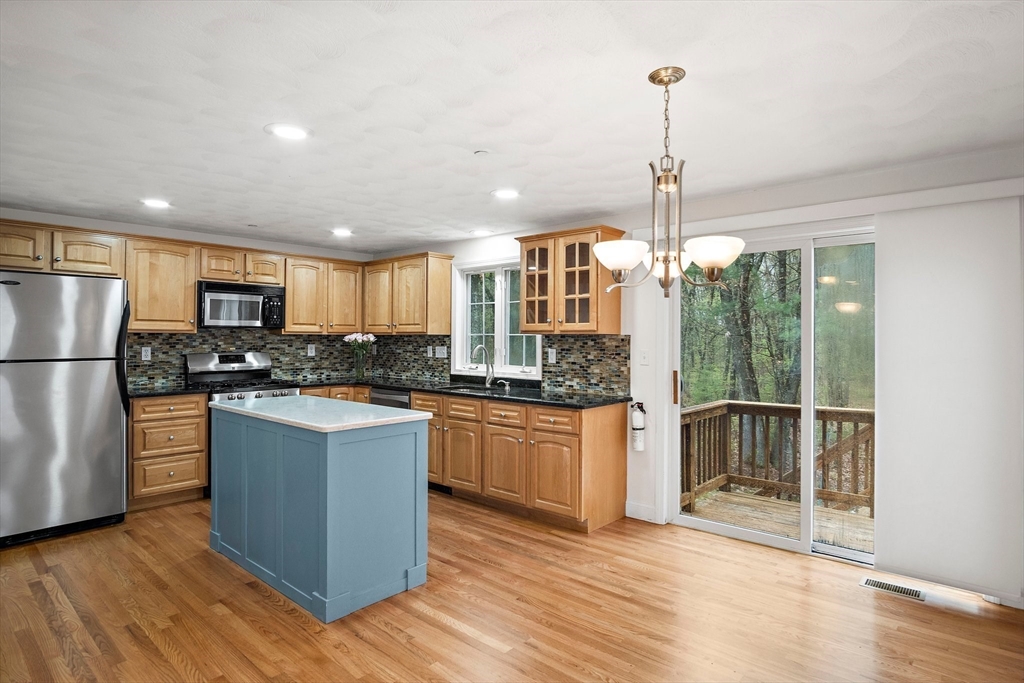 81 Salem Road, Unit 21 Billerica, MA 01821 - Photo 3 of 21 a kitchen with stainless steel appliances granite countertop a refrigerator a sink dishwasher a oven and a dining table with wooden floor