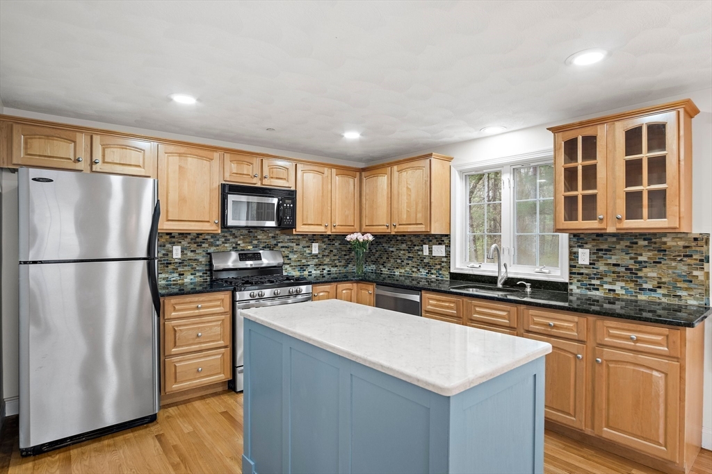 81 Salem Road, Unit 21 Billerica, MA 01821 - Photo 4 of 21 a kitchen with granite countertop stainless steel appliances a refrigerator a stove a sink cabinets and a window