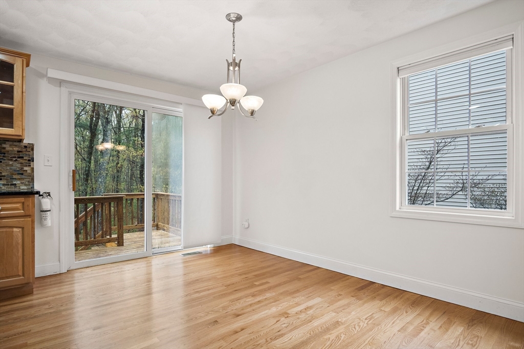 81 Salem Road, Unit 21 Billerica, MA 01821 - Photo 5 of 21 an empty room with wooden floor and windows