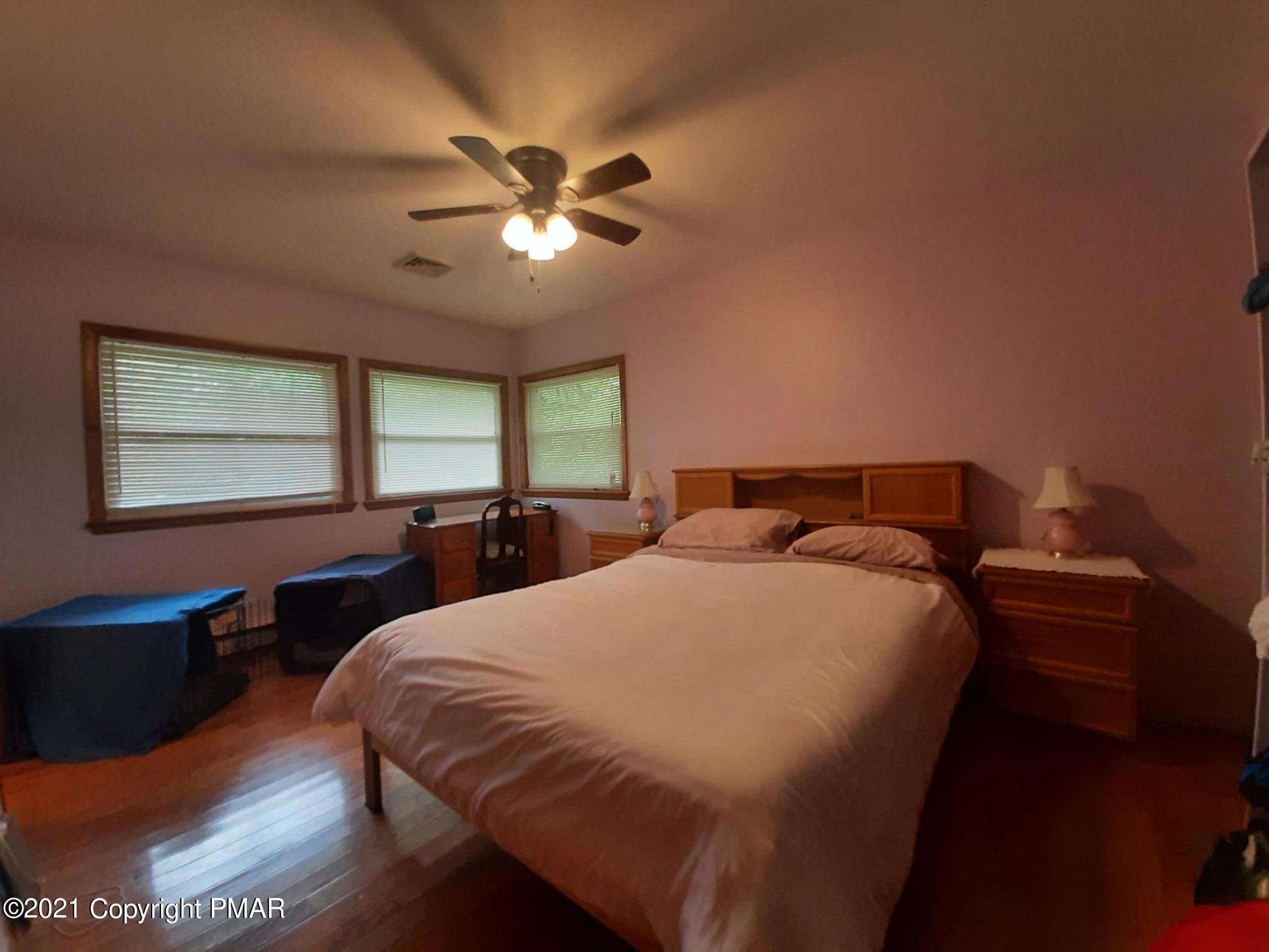 235 Dyson Road Swiftwater, PA 18370 - Photo 18 of 36 a bedroom with a large bed and a chandelier
