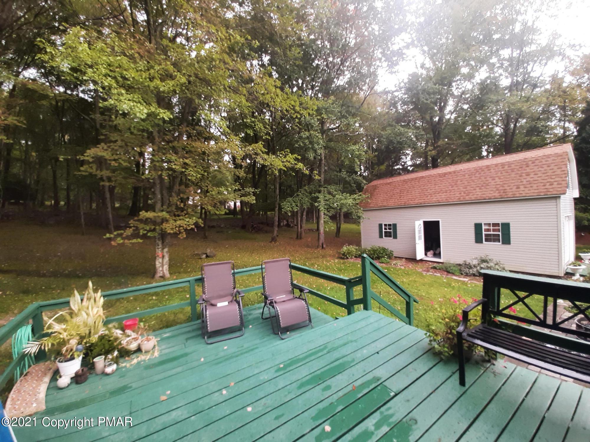 235 Dyson Road Swiftwater, PA 18370 - Photo 27 of 36 a view of a deck with chairs a barbeque with wooden floor and fence next to a yard