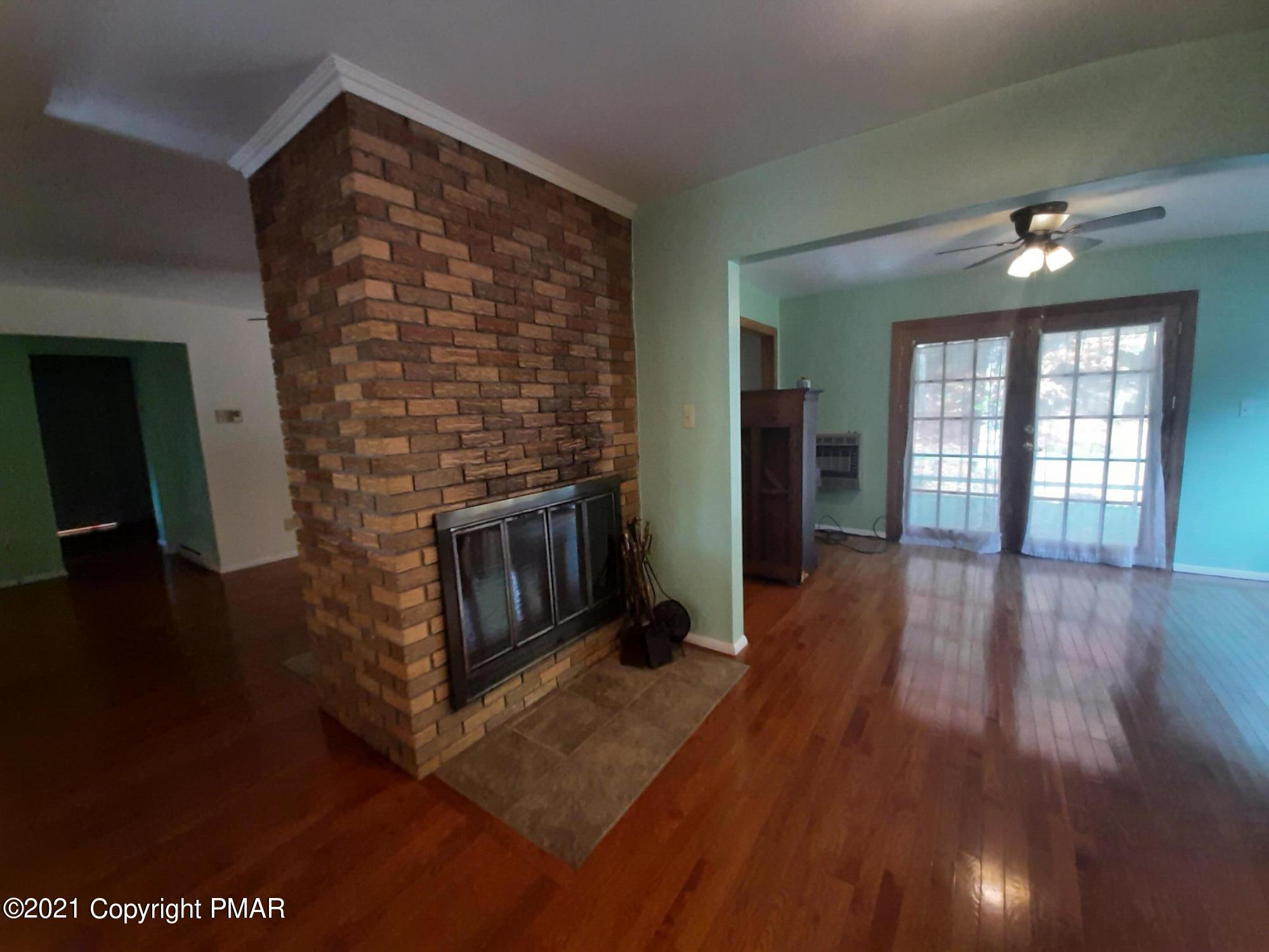 235 Dyson Road Swiftwater, PA 18370 - Photo 8 of 36 wooden floor in an empty room with a fireplace