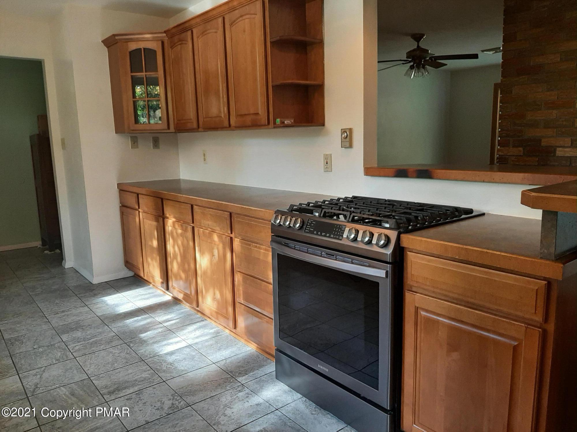 235 Dyson Road Swiftwater, PA 18370 - Photo 9 of 36 a kitchen with granite countertop a stove top oven microwave and cabinets
