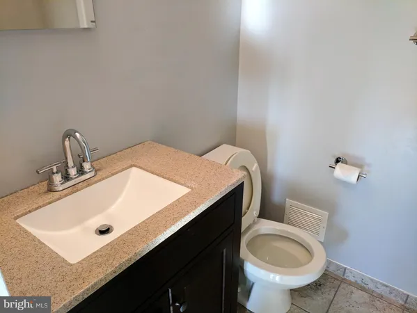 a bathroom with a sink mirror vanity and toilet