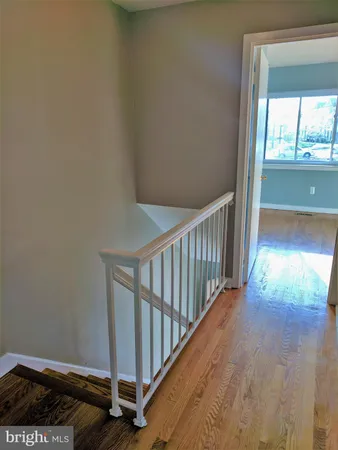 a view of a hallway with wooden floor and a window