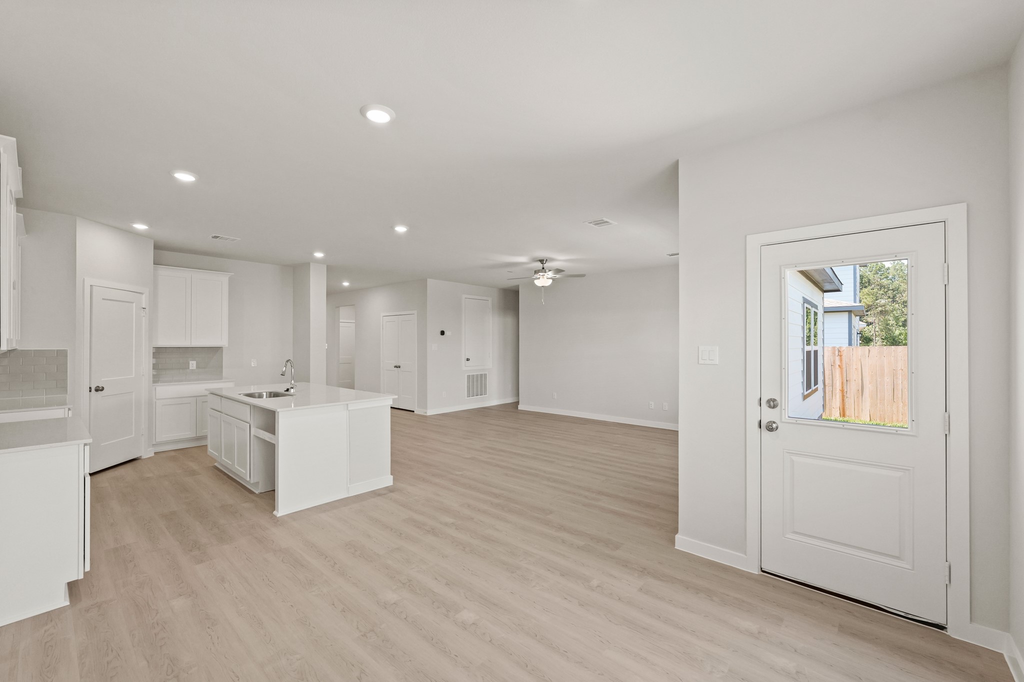 9782 Caney Bend Road Conroe, TX 77303 - Photo 8 of 32 a living room with kitchen island wooden floor and white cabinets