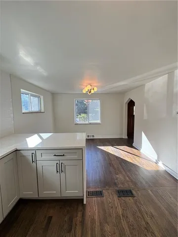 a kitchen with a sink and wooden floor