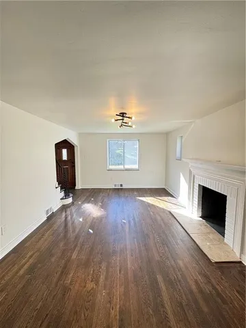 a view of a livingroom with wooden floor and fireplace