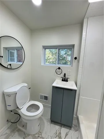 a bathroom with a toilet sink and mirror