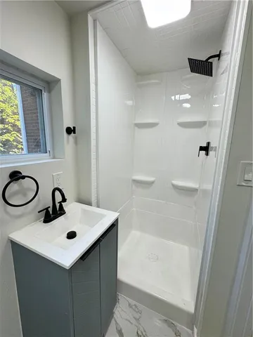 a bathroom with a sink a mirror and a shower