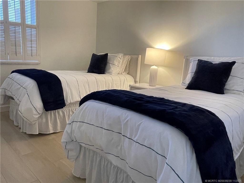 484 Northeast Plantation Road, Unit 4103 Stuart, FL 34996 - Photo 11 of 19 a bedroom with a bed and a night stand