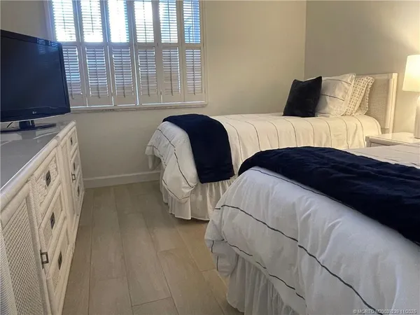 a bedroom with a bed and a flat tv screen on dresser