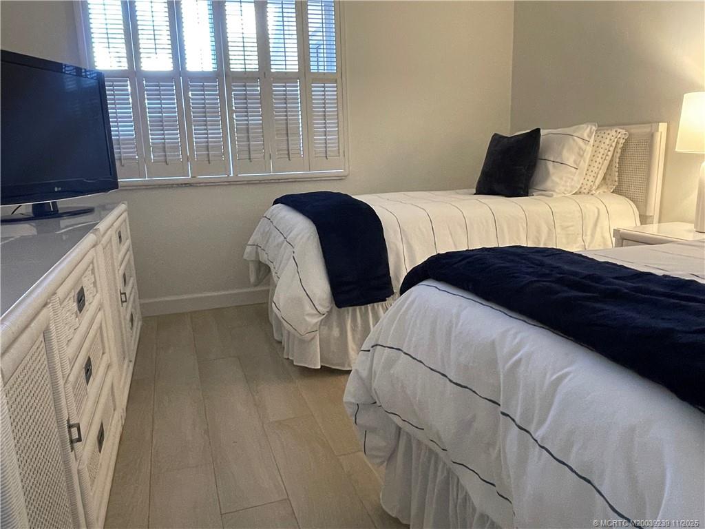 484 Northeast Plantation Road, Unit 4103 Stuart, FL 34996 - Photo 12 of 19 a bedroom with a bed and a flat tv screen on dresser