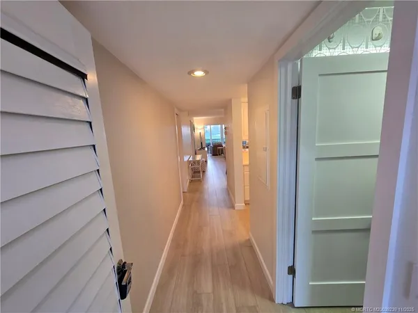 a view of a hallway with wooden floor and staircase