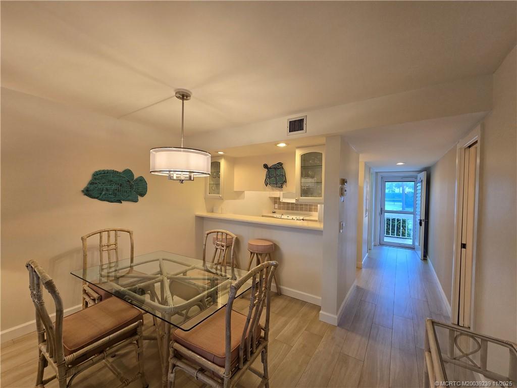 484 Northeast Plantation Road, Unit 4103 Stuart, FL 34996 - Photo 6 of 19 a view of a dining room with furniture and wooden floor