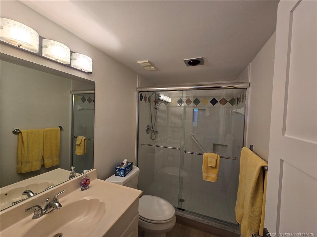 484 Northeast Plantation Road, Unit 4103 Stuart, FL 34996 - Photo 10 of 19 a bathroom with a sink mirror toilet and shower