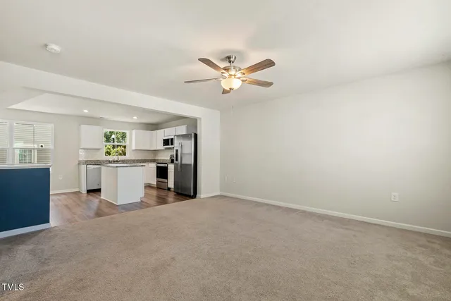 a view of a livingroom with a ceiling fan and window