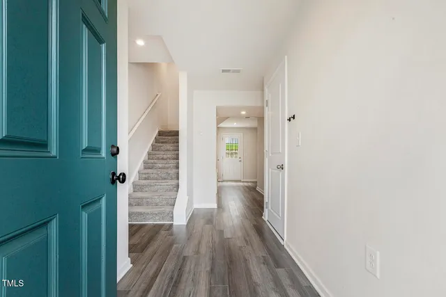 a view of a hallway with wooden floor and staircase