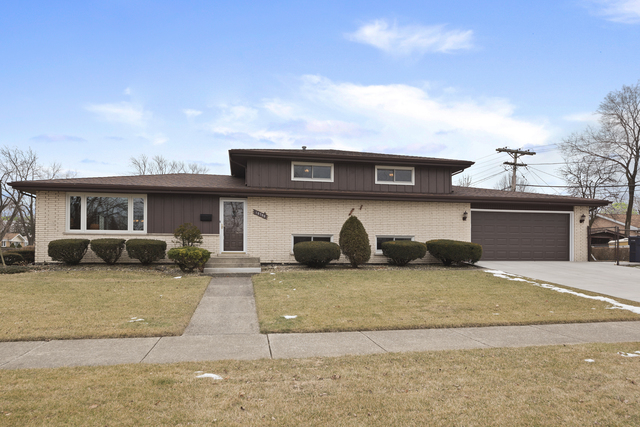 10700 Austin Avenue Chicago Ridge, IL 60415 - Photo 1 of 19 a front view of a house with a yard and garage