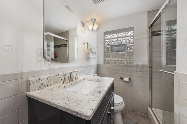10700 Austin Avenue Chicago Ridge, IL 60415 - Photo 15 of 19 a bathroom with a granite countertop sink toilet and shower