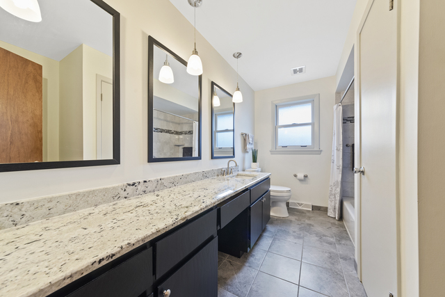 10700 Austin Avenue Chicago Ridge, IL 60415 - Photo 10 of 19 a bathroom with a granite countertop sink and a large mirror