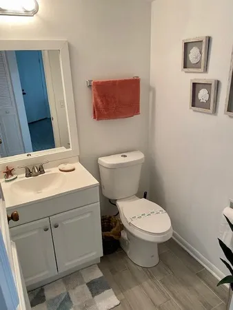 a bathroom with a toilet sink and mirror