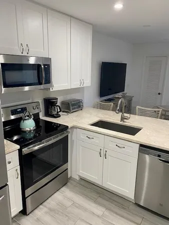 a kitchen with stainless steel appliances granite countertop a sink stove and microwave