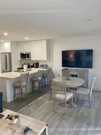 a living room with furniture a flat screen tv and kitchen view