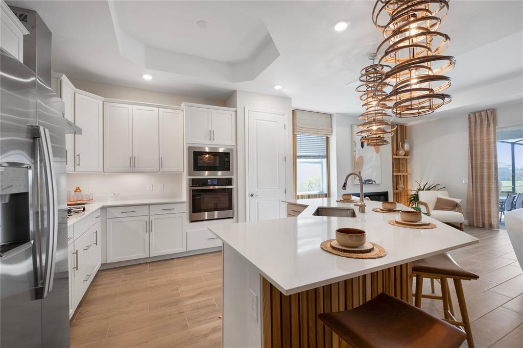 7157 Inlet Isles Lakewood Ranch, FL 34202 - Photo 5 of 26 a kitchen with sink a stove and chairs