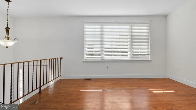 a view of a room with wooden floor and a window