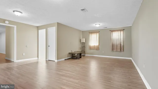 an empty room with wooden floor and a window
