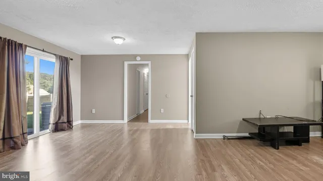 an empty room with wooden floor and a window