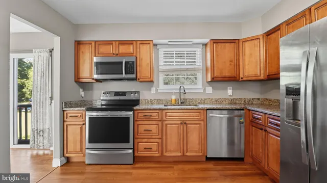 a kitchen with stainless steel appliances granite countertop a stove top oven a sink and dishwasher