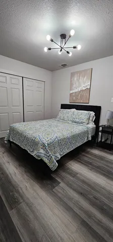 a bedroom with a bed and lamp with the wooden floor