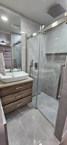 a bathroom with a double vanity sink and a shower